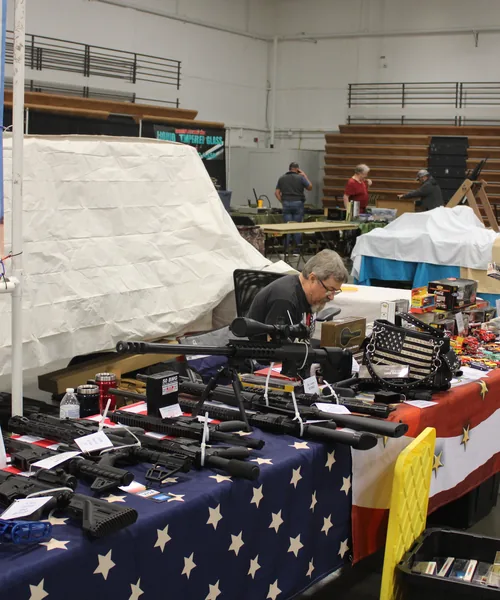Firearms lined up on a vendor table