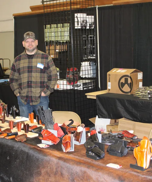 Vendor tables draped in flags with handguns and accessories